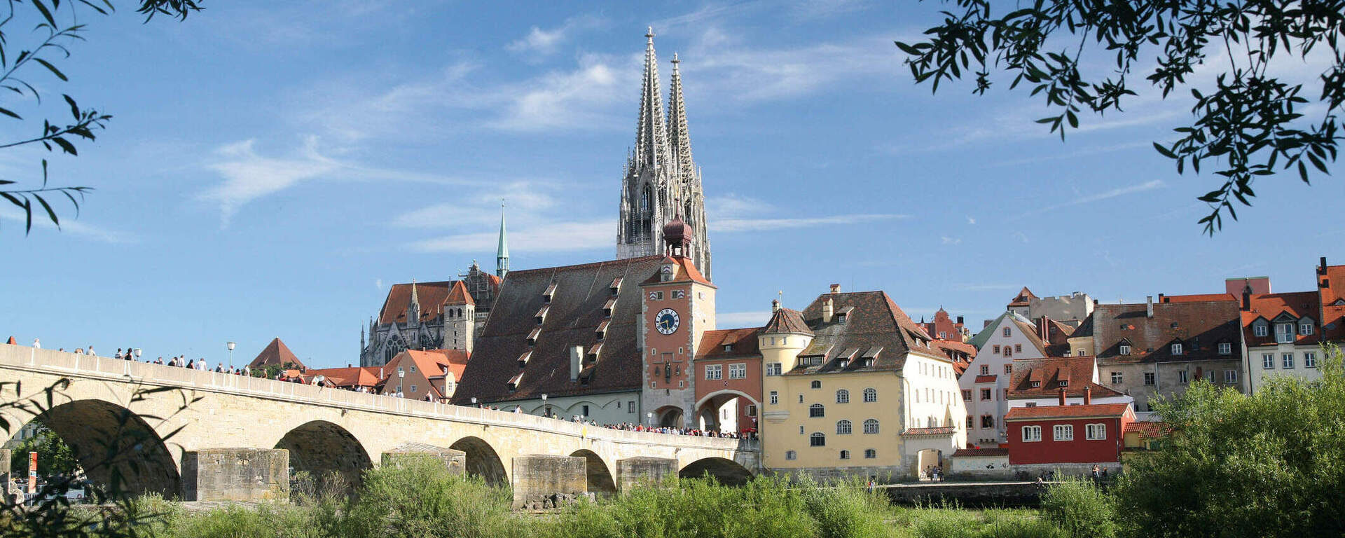 Eine malerische Steinbrücke überspannt den Fluss vor der Altstadt von Regensburg.